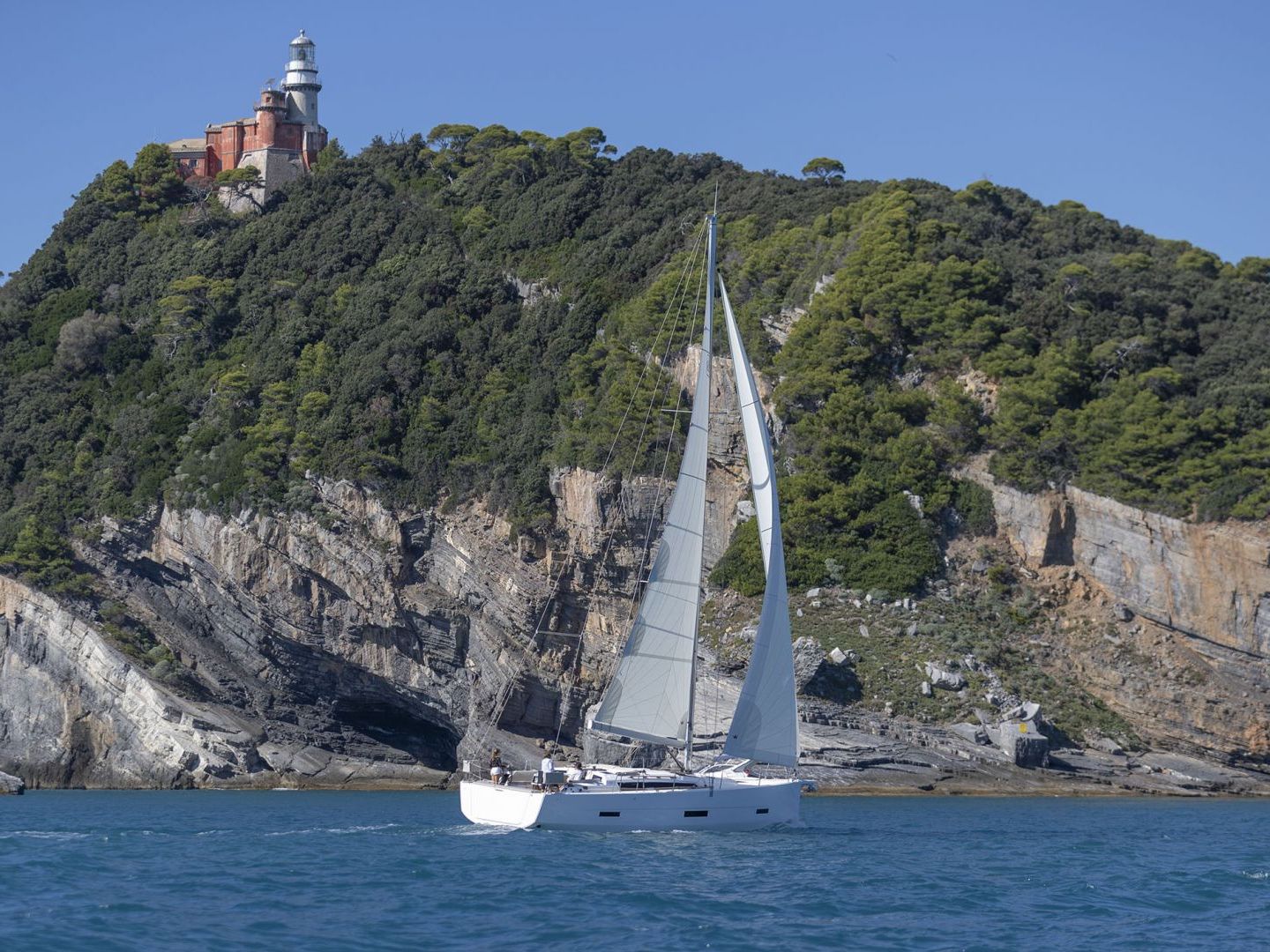 a large ship in a body of water with a mountain in the background