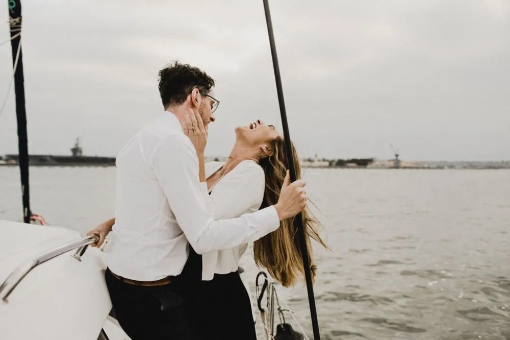 a man and a woman standing next to a body of water